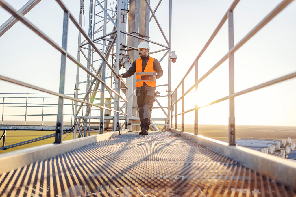 Worker in safety vest and hard hat on an industrial platform — fired for being sick California employment rights