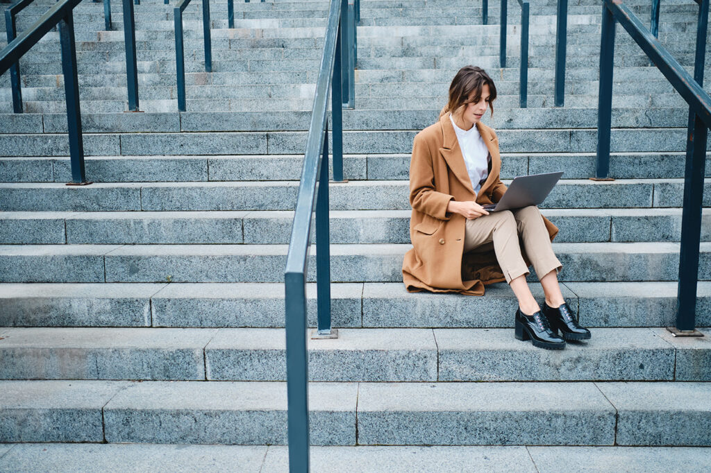 Employee sitting outside with a laptop researching when does harassment become unlawful