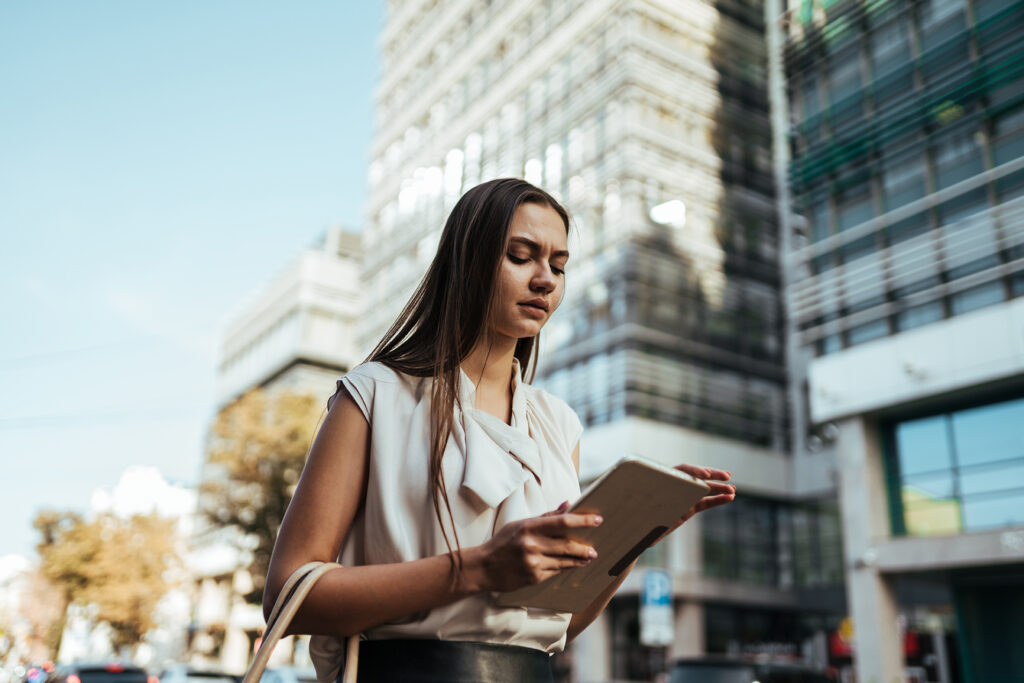 Employee reviewing information on a tablet outside an office building after experiencing workplace retaliation in Menifee California