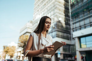 Employee reviewing information on a tablet outside an office building after experiencing workplace retaliation in Menifee California