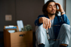 Man sitting with a packed box of office belongings after wrongful termination in California