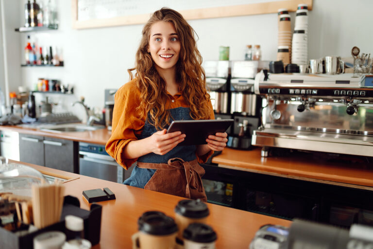 Smiling employee holding a tablet at work, representing someone navigating a workplace retaliation situation